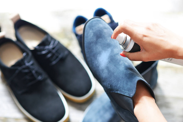 Shoes care concept with woman hands spraying leather shoe - Fotoğraf, Görsel