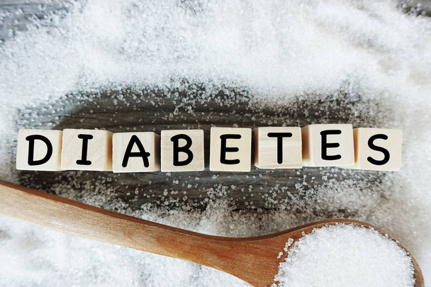 Palabra de diabetes en letras de madera con azúcar blanca cristalizada como marco
  - Foto, imagen