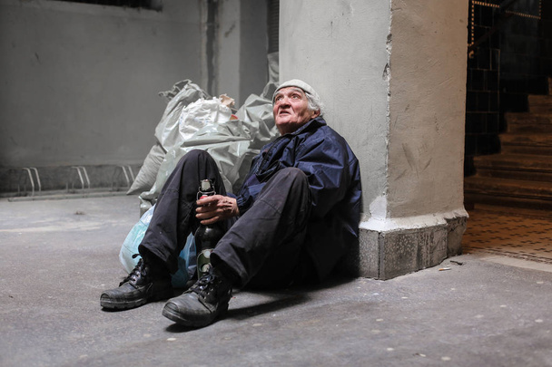 бездомний чоловік сидить на вулиці
 - Фото, зображення