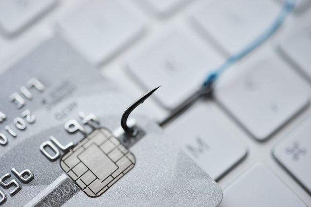 Hakkerointi ja phishing hyökkäys internetissä käsite luottokortilla kalastuskoukku tietokoneen näppäimistöllä
 - Valokuva, kuva
