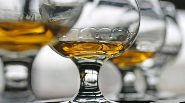 Ierse whisky toont haar benen in een glas op een balk in een close-up foto. - Foto, afbeelding