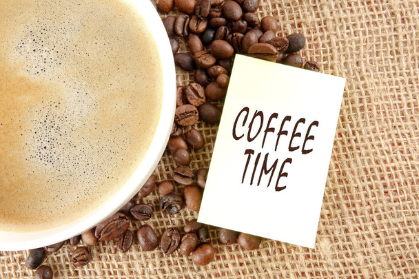 Grãos de café e uma xícara de café com CAFÉ TEMPO palavras sobre um r
 - Foto, Imagem