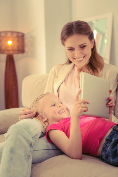 Happy cheerful girl looking at the tablet screen - Fotoğraf, Görsel