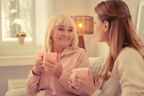 Nice aged woman holding a cup of tea - Фото, изображение