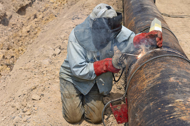 Сварщик на ремонте трубопровода
 - Фото, изображение