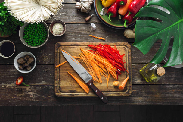 Raw ingredients for cooking vegetarian thai noodles on dark wooden table in home kitchen top view - 写真・画像