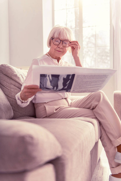 Sapient lady attentively reading a fresh newspaper - Фото, зображення