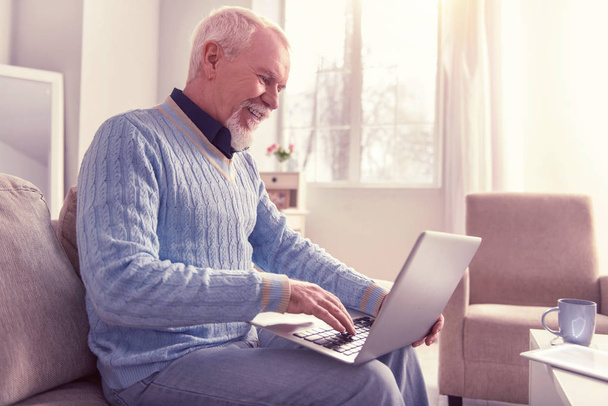 Cheerful white-haired pensioner working with new notebook - Valokuva, kuva
