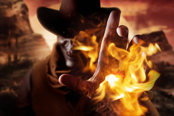 Kuva demoninen kallo pää cowboy hattu heittää tulipalo loitsu kätensä auringonlaskun aavikon taustalla
. - Valokuva, kuva