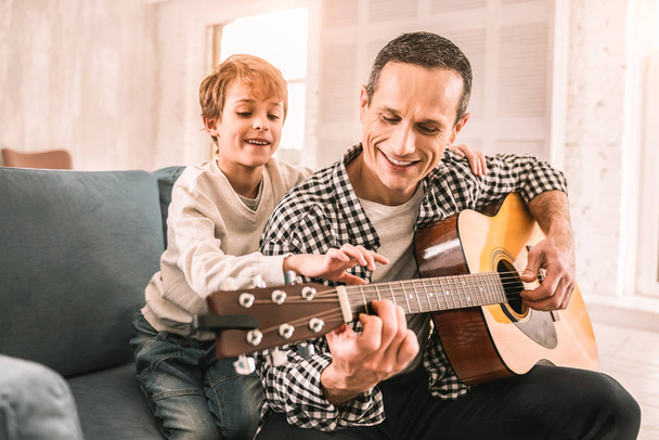 Smart little kid giving his dad a piece of musical advice. - Photo, image
