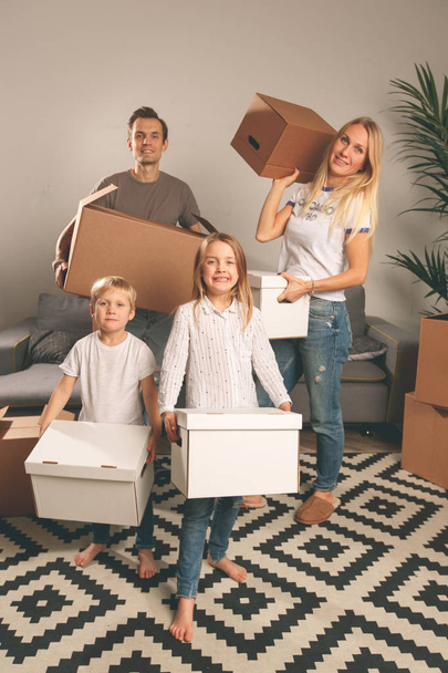 Full-length photo of women, men and children holding cardboard boxes - 写真・画像