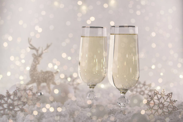 Yeni yıl ve Noel kutlamaları. İki şampanya bardakları ve tatil dekorasyon. Noel için güzel parlak yer ayarı. Maytap arka plan, kış sezonu.  - Fotoğraf, Görsel