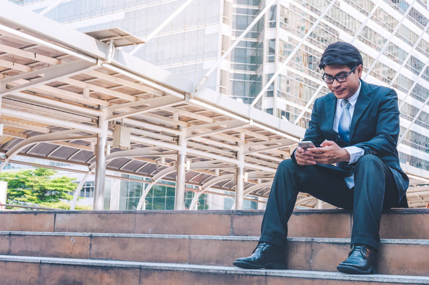 hombre de negocios en traje usando teléfono inteligente en la ciudad
 - Foto, Imagen