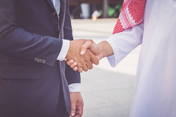 Арабский бизнесмен пожимает руку своему деловому партнеру на строительной площадке
 - Фото, изображение