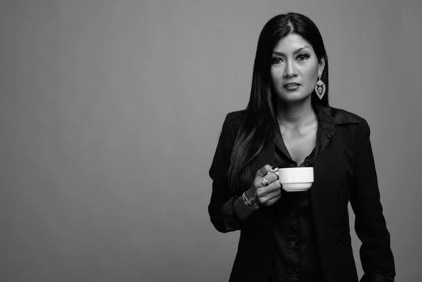 灰色の背景で成熟した美しいアジア女性実業家  - 写真・画像
