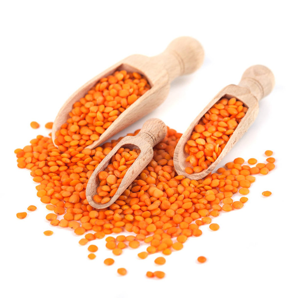 Red lentils in the wooden spoon, isolated on white background - Photo, Image