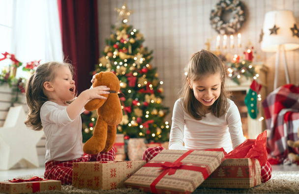 girls opening Christmas gifts - Фото, изображение