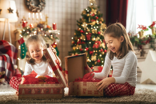 girls opening Christmas gifts - Foto, afbeelding
