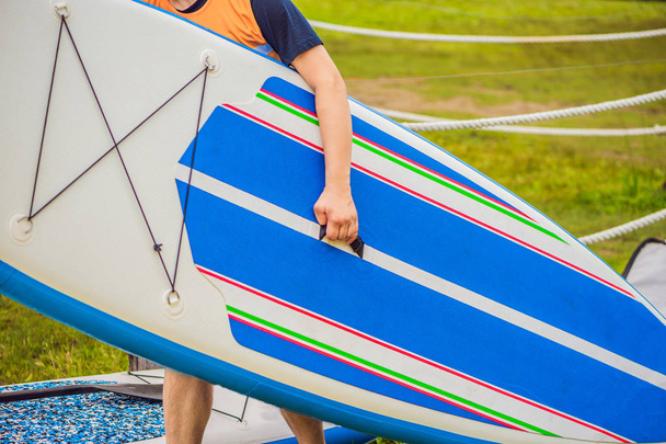 SUP boards lying on the grass by the river, lake or sea - Photo, Image