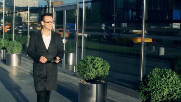 A businessman walks, holding a tablet, close up. - Záběry, video