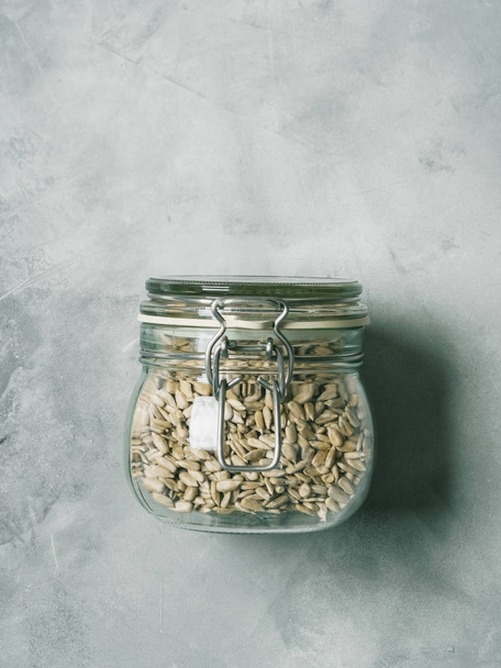 Sunflower seeds in glass jar on concrete background - 写真・画像