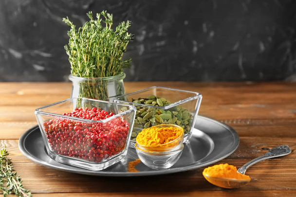 Bowls with different aromatic spices and thyme on metal tray - Фото, изображение