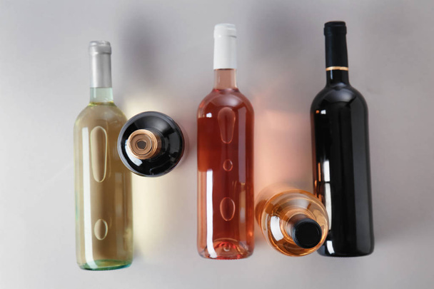 灰色の背景の上にワインの異なる種類のボトル - 写真・画像