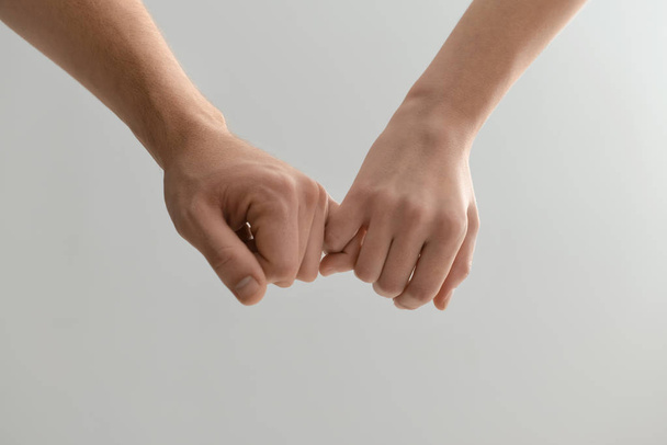 Man and woman holding hands on light background - Photo, Image