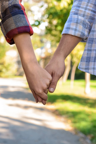Young couple holding hands outdoors - Photo, Image