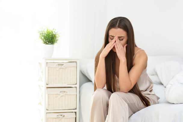 Frau leidet unter Kopfschmerzen im Schlafzimmer - Foto, Bild
