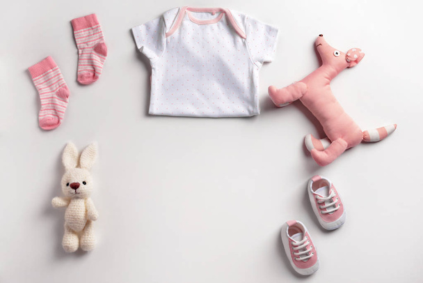 Söpö vauvan vaatteita ja leluja valkoisella taustalla
 - Valokuva, kuva