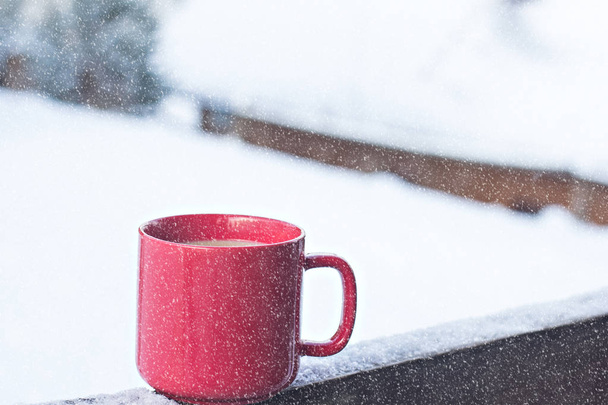 Cup with coffee, tea on the background of the winter landscape.  A cup with a hot drink on the background of the winter forest. the table outdoor in the winter. Winter time concept. - Foto, Bild