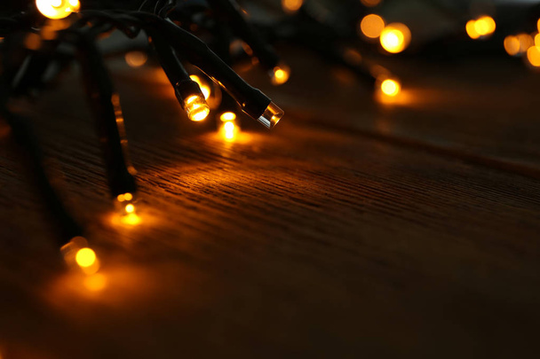 Glowing Christmas lights on table, closeup - Foto, afbeelding