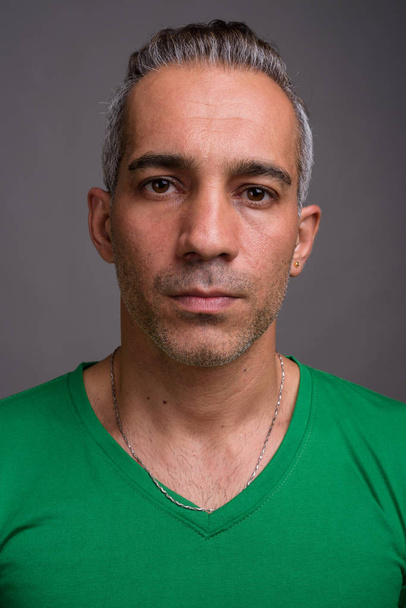 Όμορφος Περσικά άνδρα με γκρίζα μαλλιά που φοράει πράσινο μπλουζάκι - Φωτογραφία, εικόνα