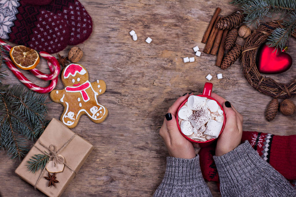 Cadeau, cônes, cadeaux, café, cacao. Noël, fond Nouvel An. La main d'une femme tient une tasse. Hiver, Nouvel An, Noël nature morte.  - Photo, image
