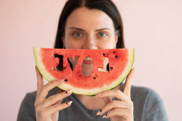 portrait of a young beautiful girl holding a slice of watermelon - Фото, зображення