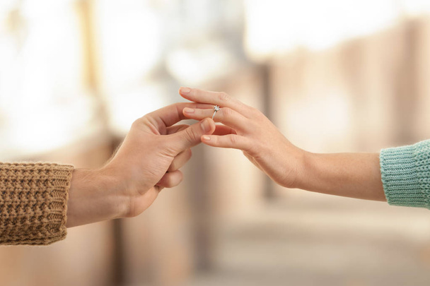Jonge man brengen verlovingsring aan verloofde van vinger - Foto, afbeelding