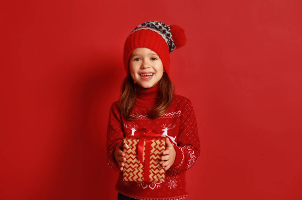 heureuse fille enfant avec cadeau de Noël sur fond rouge
 - Photo, image