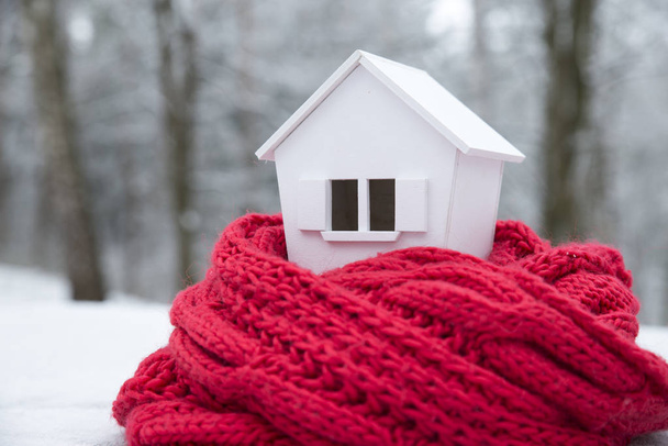 dům v zimě - topný systém koncept a studené zasněžené počasí s modelem domu pletené čepici - Fotografie, Obrázek