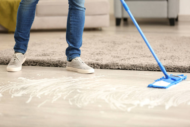 Jovem limpeza chão em seu apartamento
 - Foto, Imagem