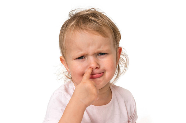 Triste petite fille se picore le nez avec le doigt à l'intérieur concept d'hygiène
 - Photo, image