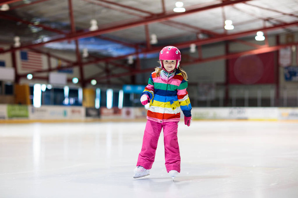 Kinder Schlittschuhlaufen auf der überdachten Eisbahn. Kinder skaten. - Foto, Bild