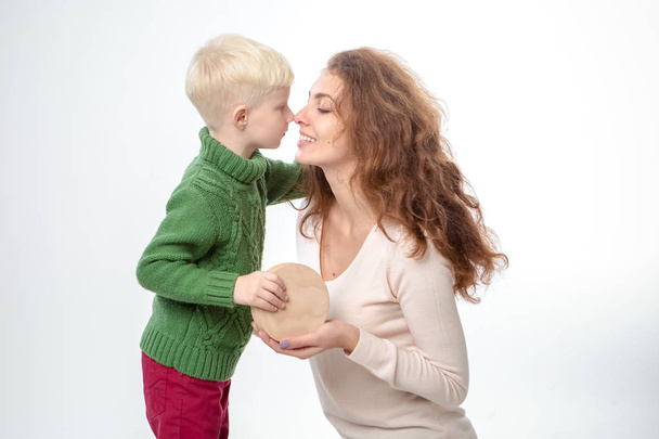 Ευτυχισμένη νεαρή μητέρα με ένα παιδί σε ανοιχτό γκρι φόντο - Φωτογραφία, εικόνα