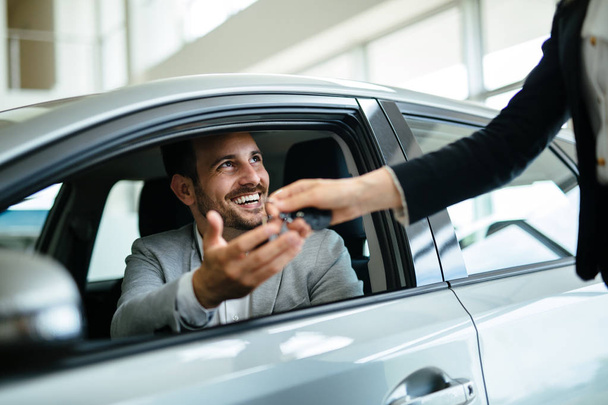 Portrait of happy young customer buying new car - Foto, imagen
