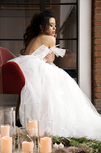 bride in white dress and dark hair preparations for the wedding - Foto, Imagen
