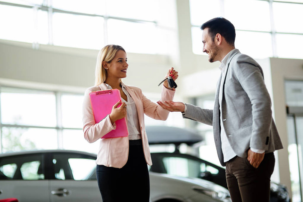 Picture of professional female salesperson working in car dealership - Photo, image