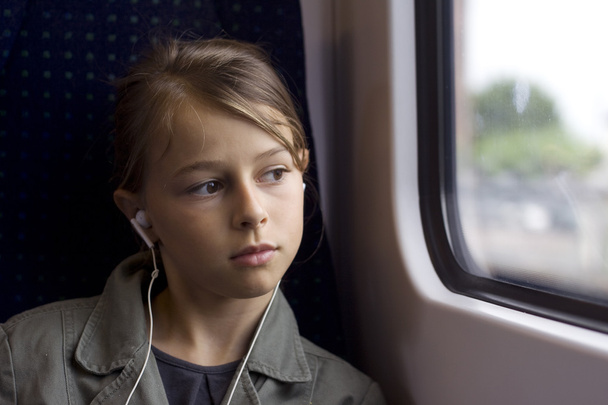 Дівчина з навушниками на автобусі або поїзді
 - Фото, зображення