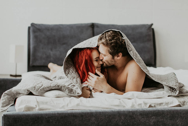Beautiful loving couple kisses in bed - Foto, Imagen