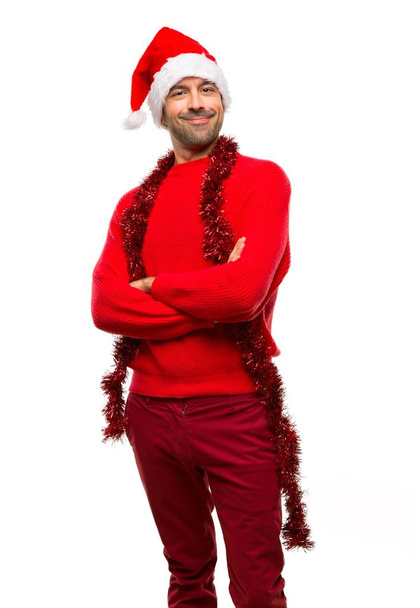 Uomo con abiti rossi che celebrano le festività natalizie tenendo le braccia incrociate in posizione frontale su sfondo bianco isolato
 - Foto, immagini