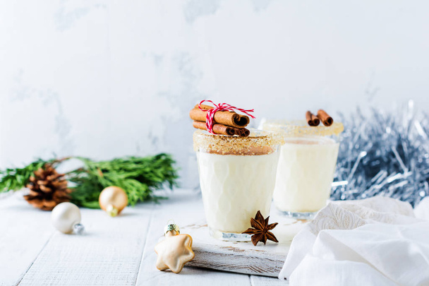 Eggnog Traditional Christmas drink milkshake with cinnamon on light old background. Selective focus. - Foto, Imagem